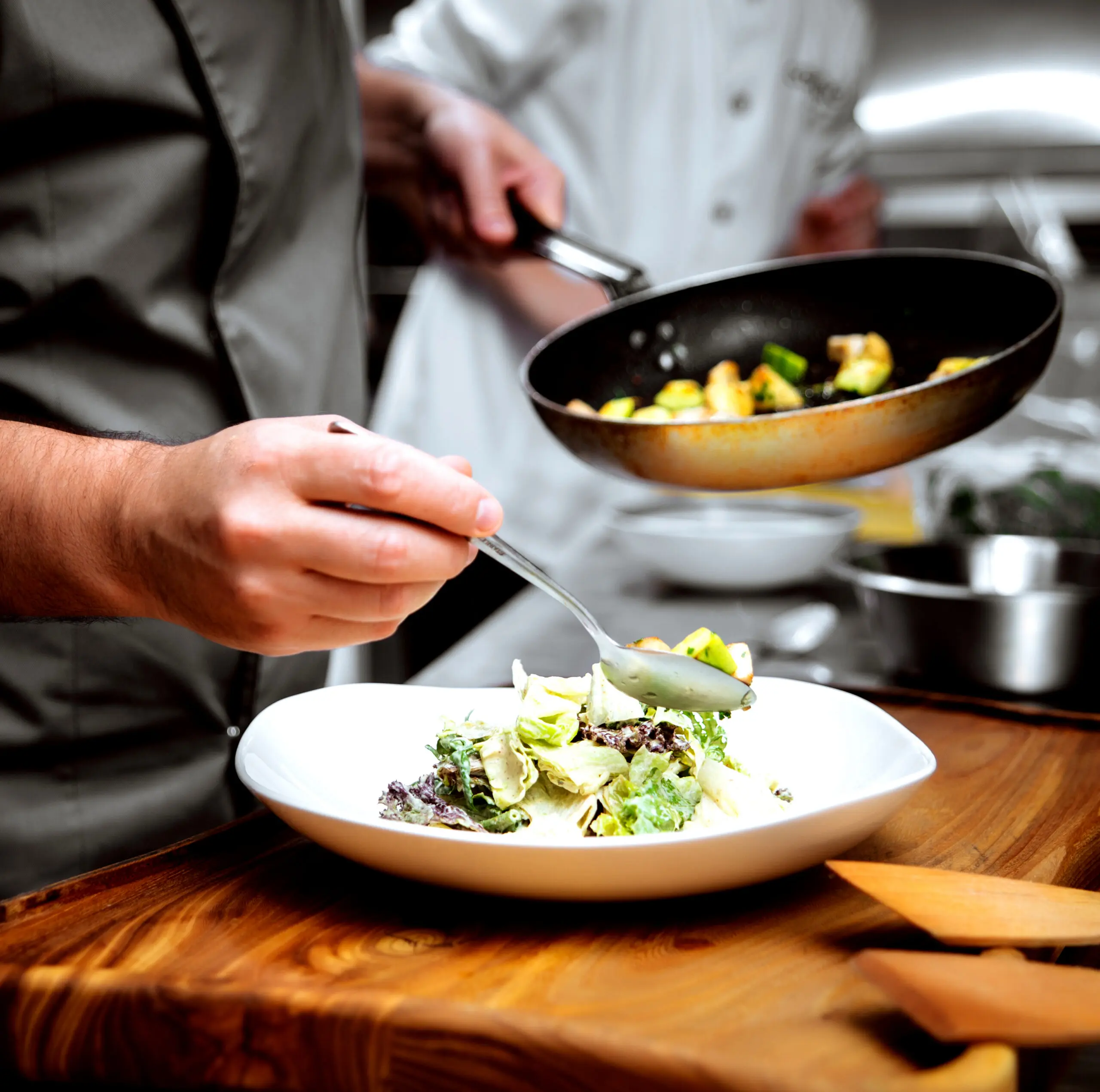Chef plating a finished dish in a kitchen