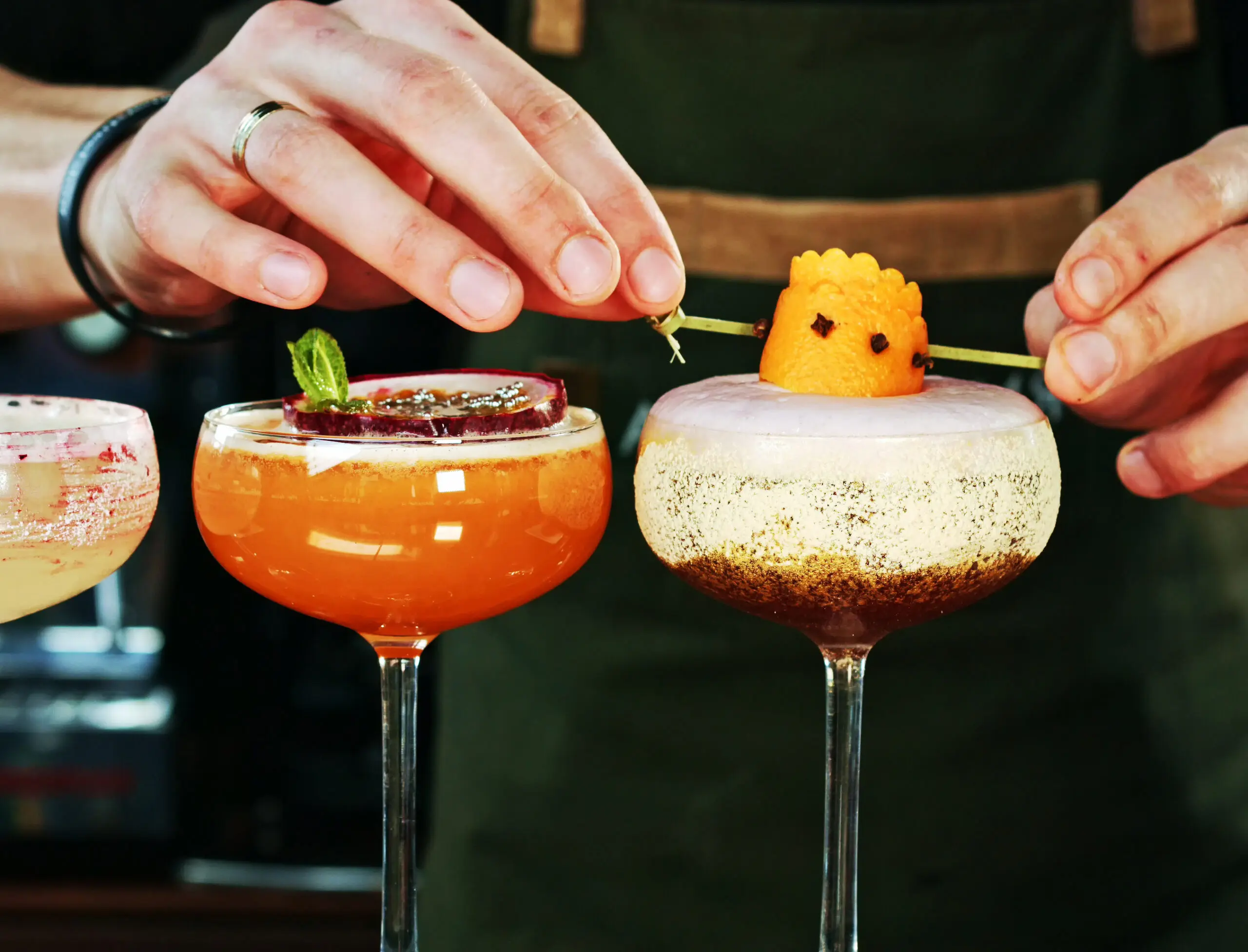 Hands garnishing crafted cocktails