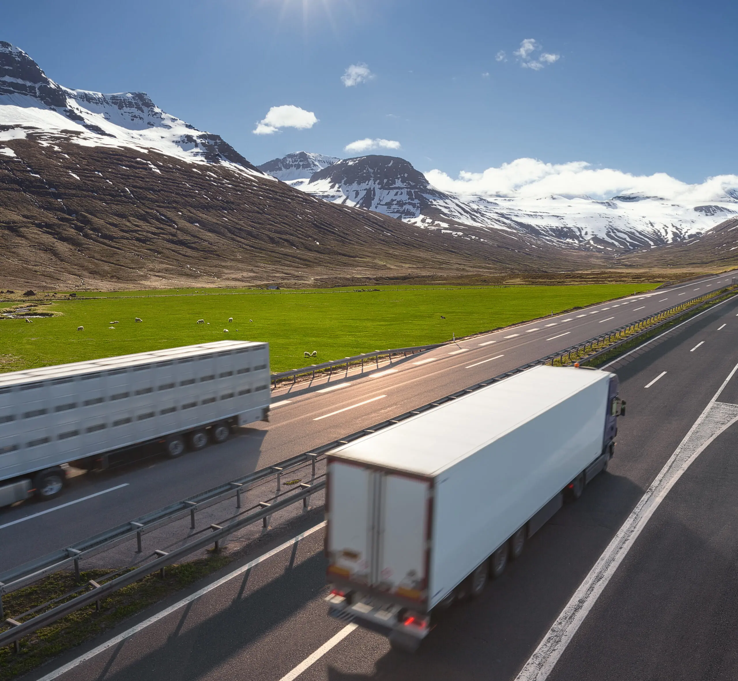 18-wheeler trucks driving past each other on highway surrounded by Canadian mountains