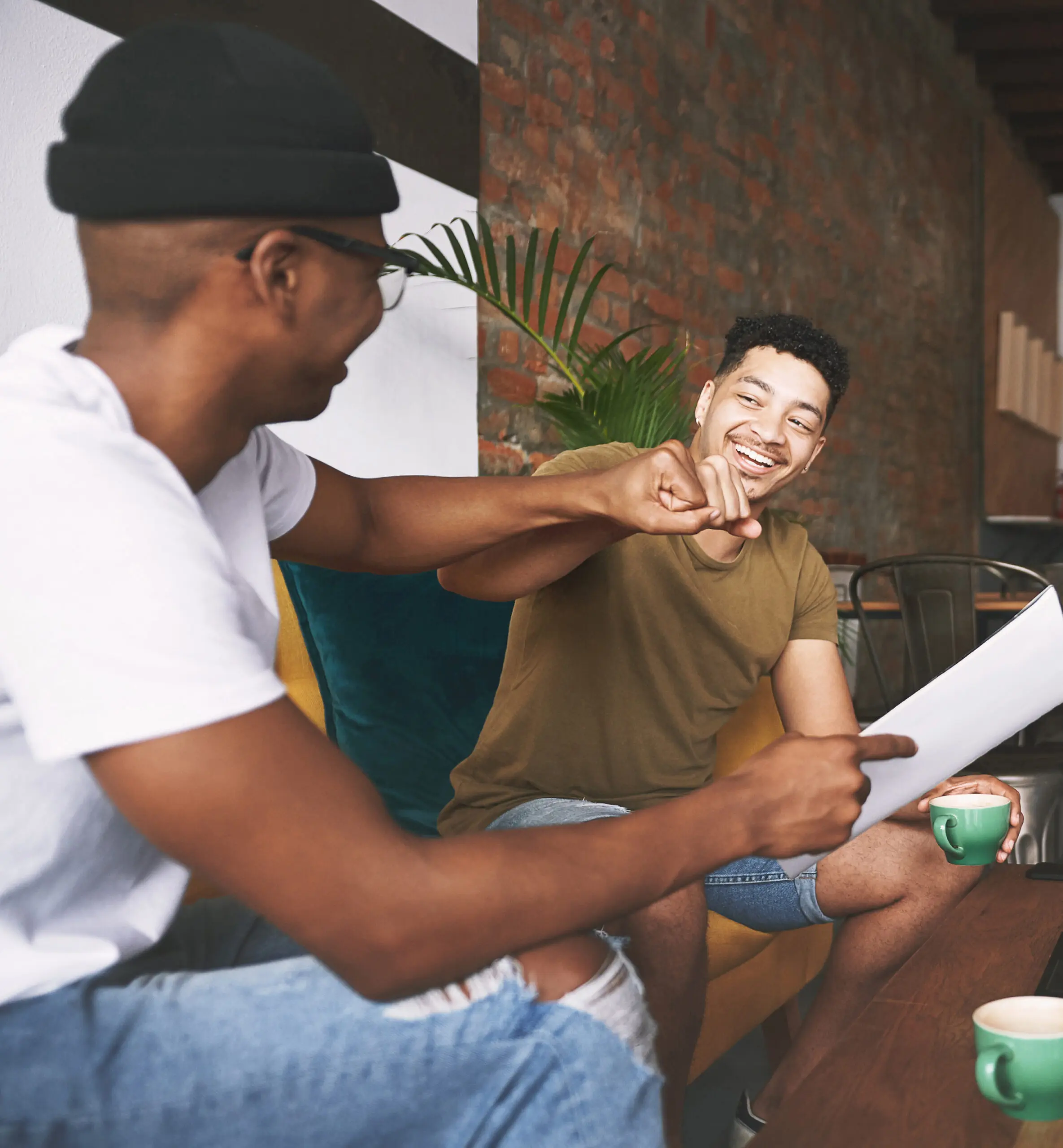 Two men fist-bumping over coffee