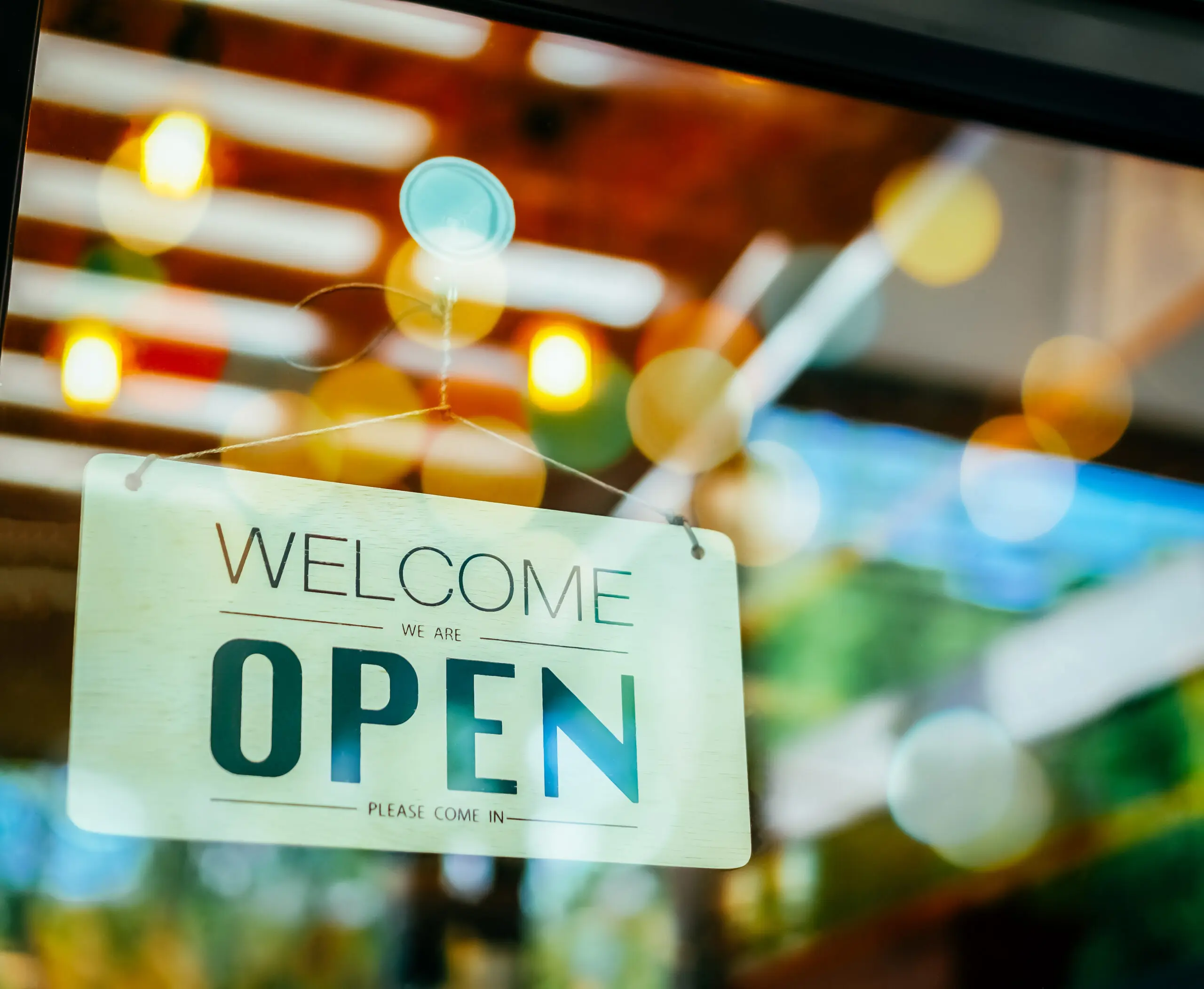 "Open” sign hanging in a restaurant window.