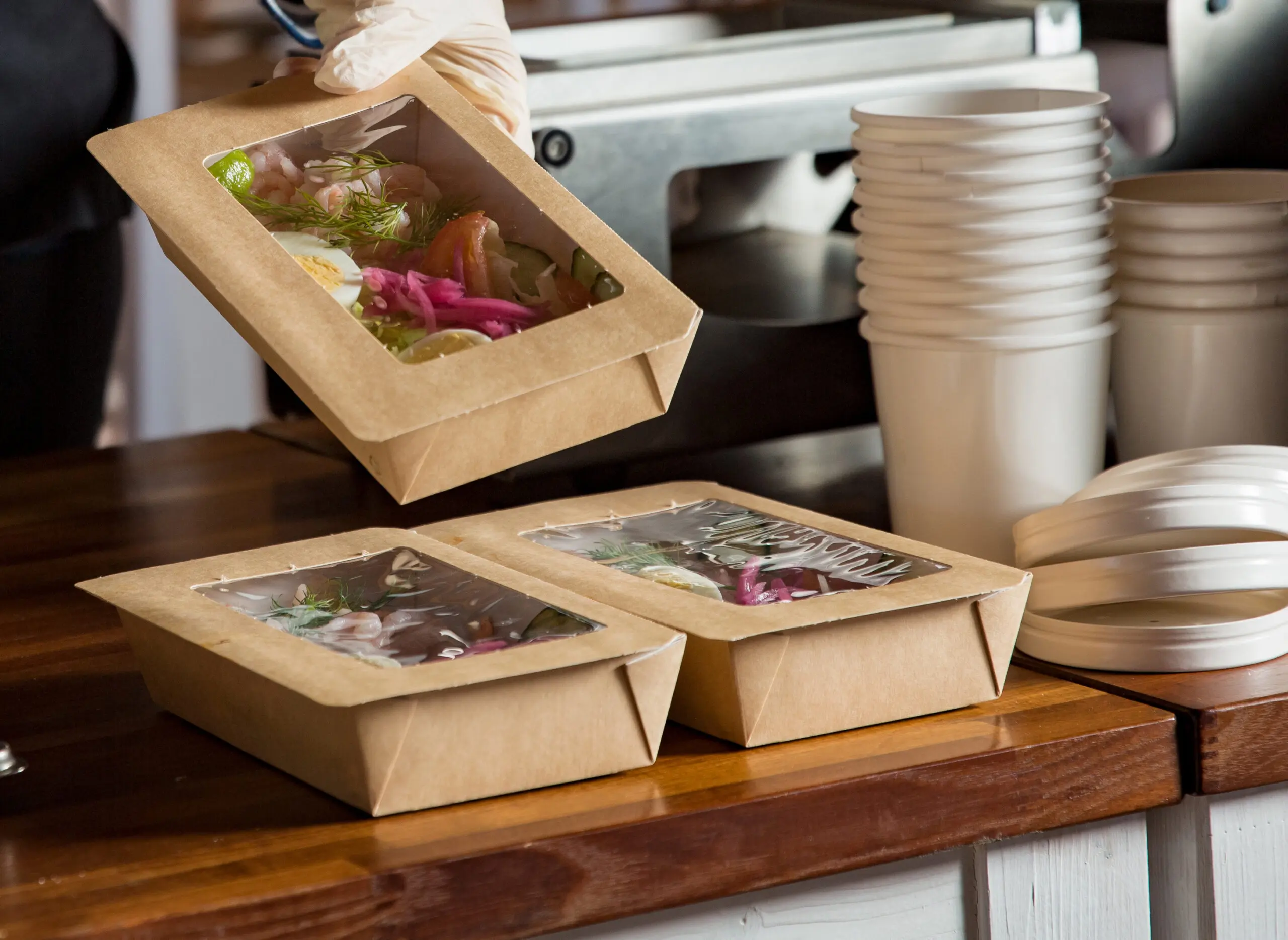 Restaurant worker prepares to-go orders for customer pick-up.