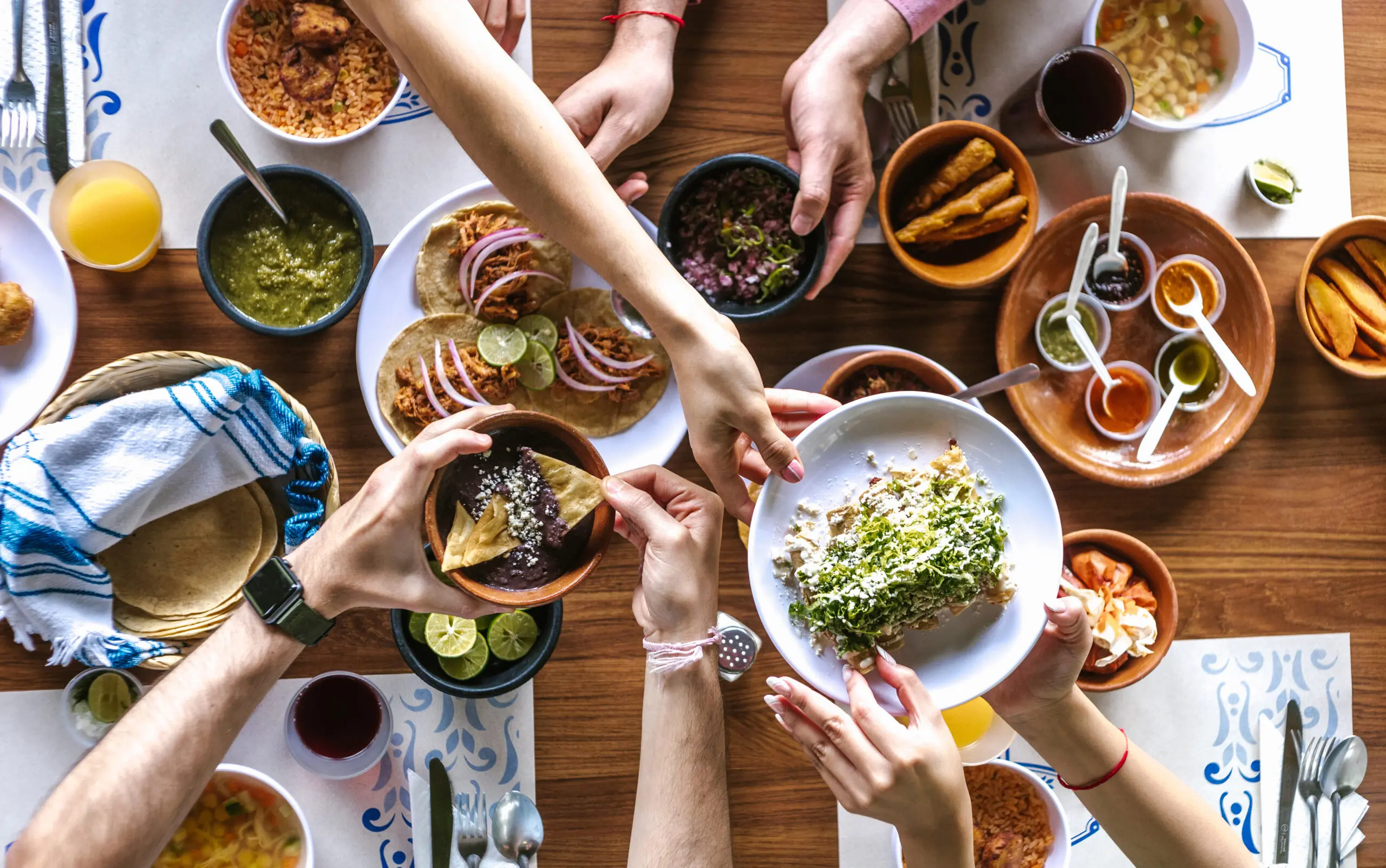 People passing plates of guacamole and nachos