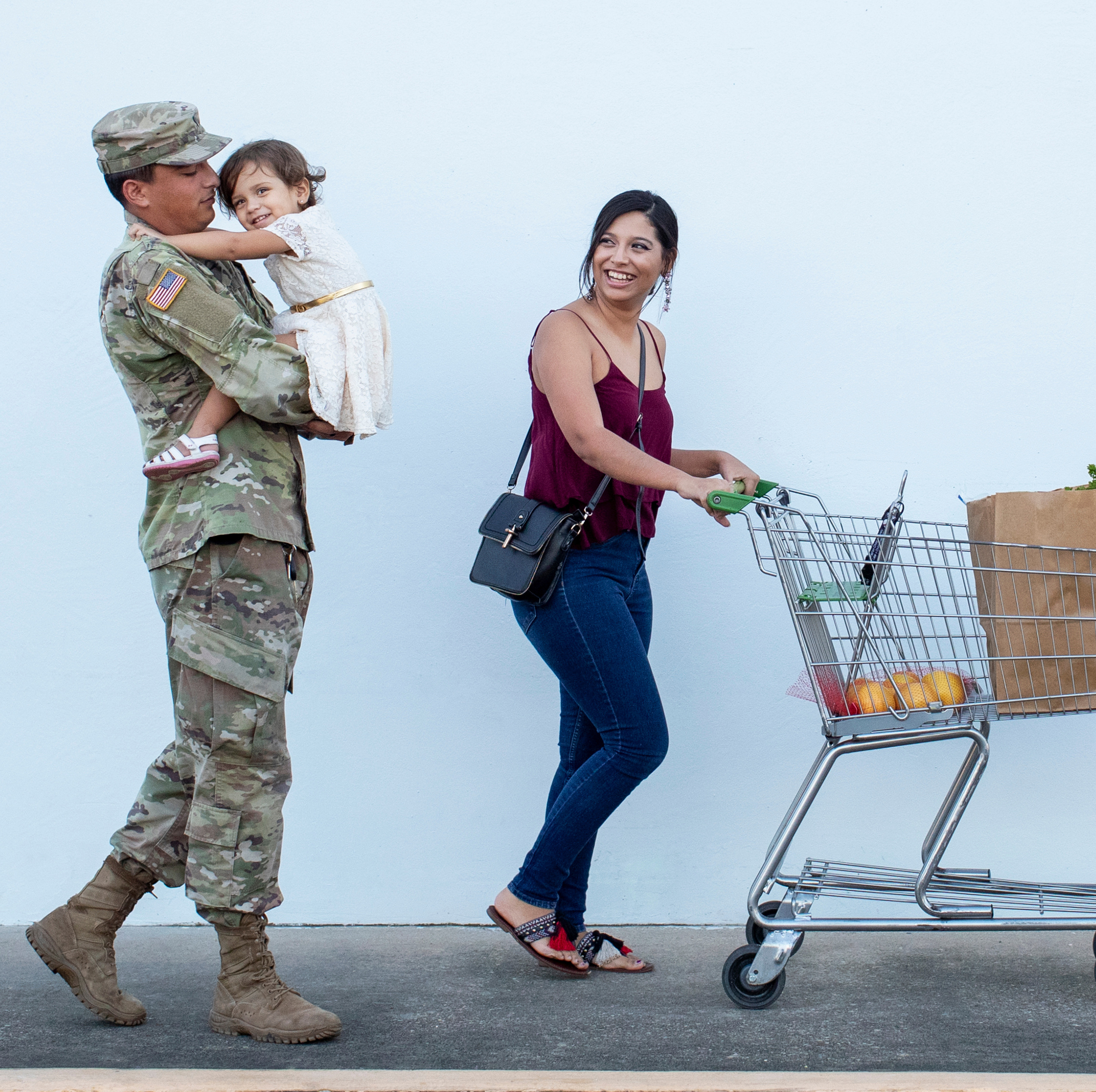 Military family walking with groceries